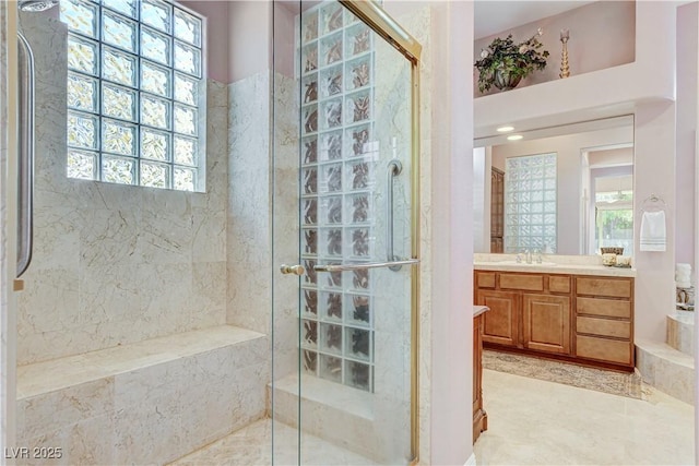 bathroom featuring a shower with door and vanity