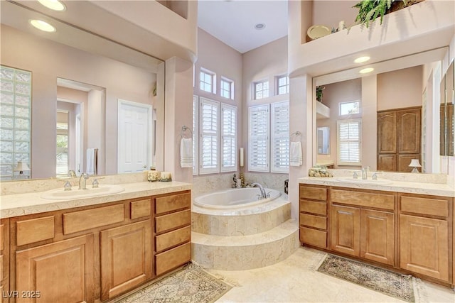 bathroom featuring vanity and tiled tub