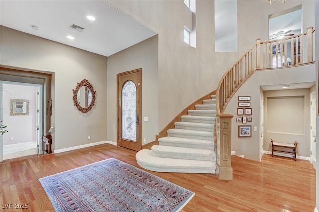 entrance foyer featuring a high ceiling, light hardwood / wood-style flooring, and ceiling fan