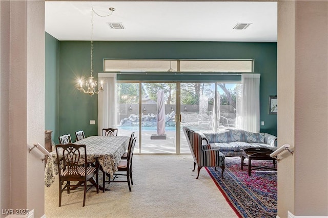 carpeted dining space with an inviting chandelier