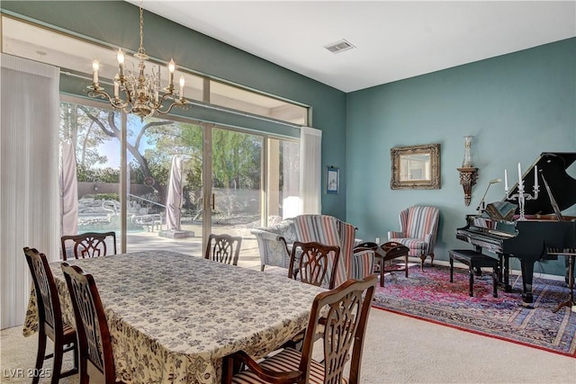 dining room with carpet and an inviting chandelier