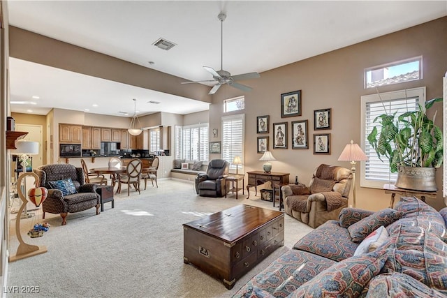 carpeted living room featuring ceiling fan