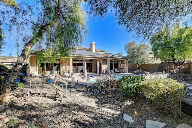 back of house featuring a fenced in pool and a patio