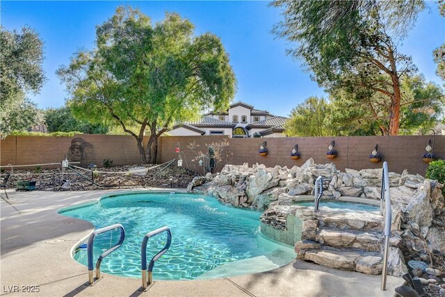 view of pool with an in ground hot tub and pool water feature