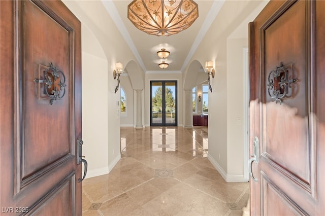 foyer with french doors and crown molding