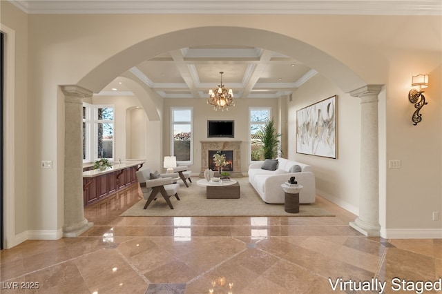 living area featuring coffered ceiling, a notable chandelier, a fireplace, ornamental molding, and beamed ceiling