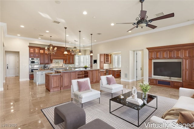 living room with ceiling fan with notable chandelier and crown molding