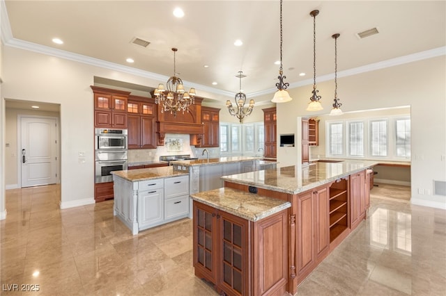 kitchen featuring a notable chandelier, hanging light fixtures, a spacious island, and light stone countertops