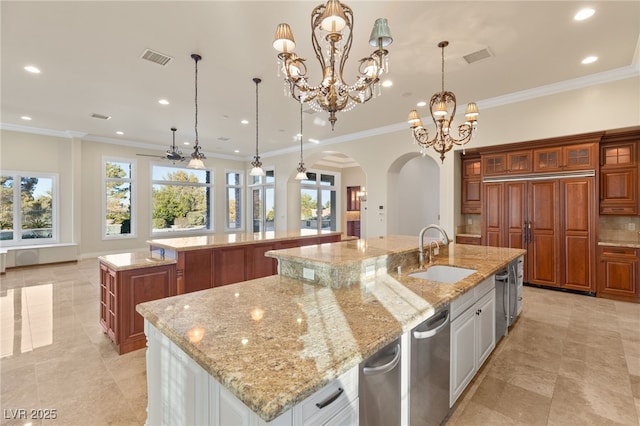 kitchen featuring a spacious island, pendant lighting, crown molding, light stone counters, and sink