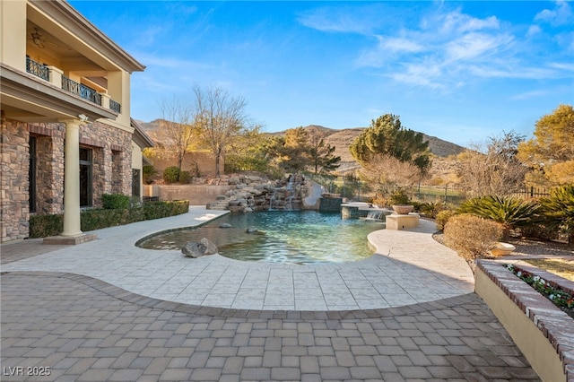 view of swimming pool with a mountain view and a patio