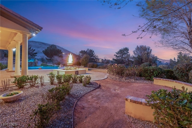 yard at dusk with a mountain view and a patio