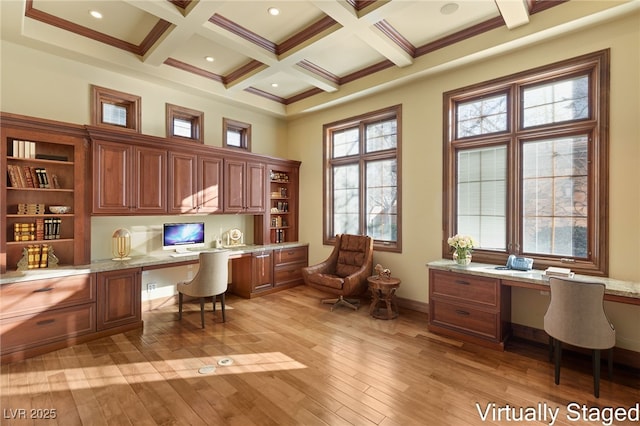 home office featuring beamed ceiling, a healthy amount of sunlight, built in desk, and coffered ceiling