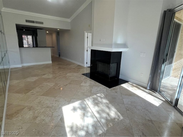 unfurnished living room featuring lofted ceiling, a fireplace with flush hearth, ornamental molding, and baseboards