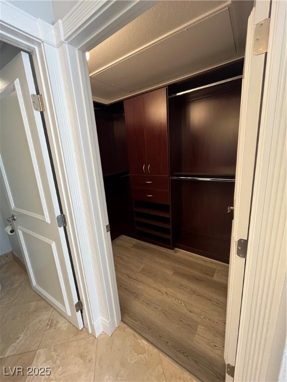 walk in closet with light tile patterned floors