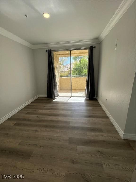 spare room featuring dark wood-style floors, baseboards, and crown molding