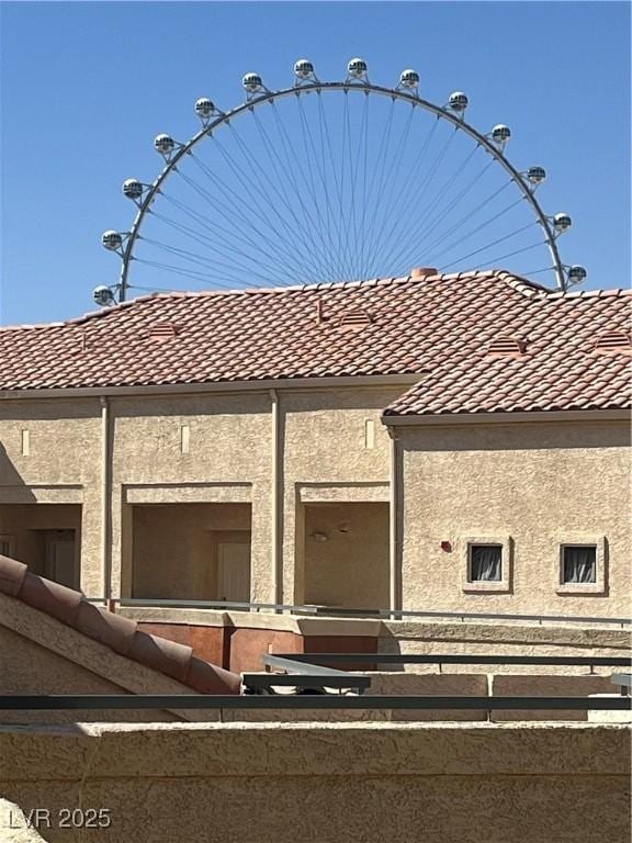 view of home's exterior with a tile roof and stucco siding