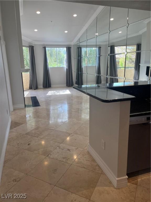 interior space with dark countertops, recessed lighting, ornamental molding, dishwasher, and baseboards