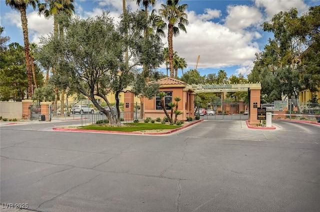 view of street with curbs, a gated entry, and a gate