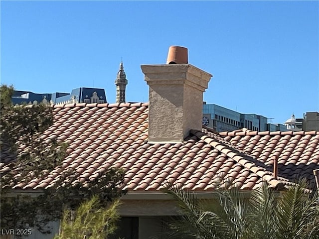 exterior details featuring a tiled roof and a chimney