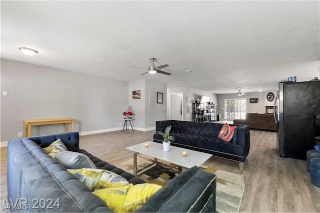 living room with ceiling fan and light hardwood / wood-style floors