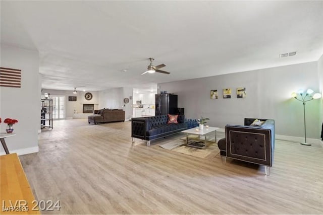 living room with ceiling fan and light hardwood / wood-style flooring