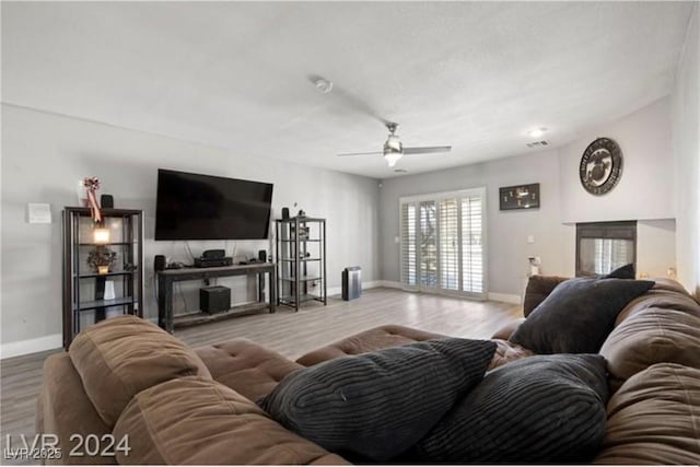 living room with ceiling fan and light hardwood / wood-style flooring