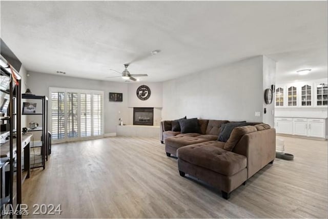 living room with light wood-type flooring and ceiling fan