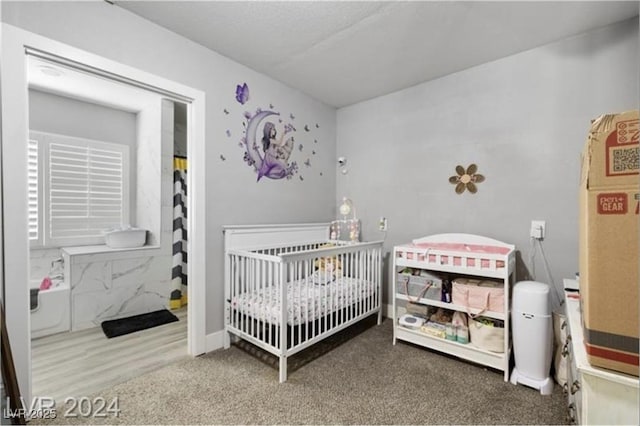 carpeted bedroom featuring a crib