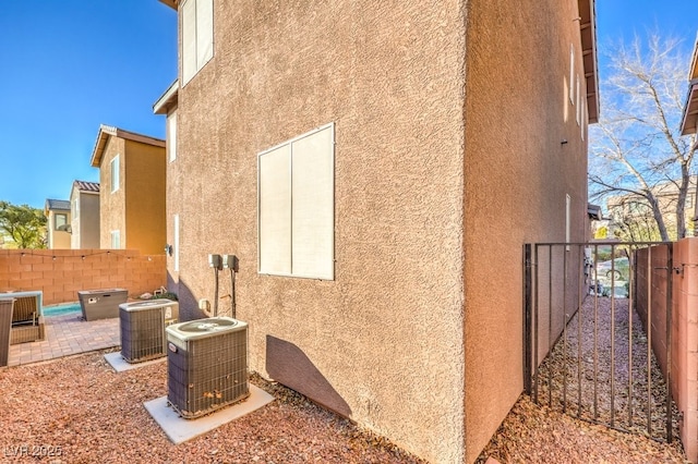 view of side of property featuring central AC unit and a patio