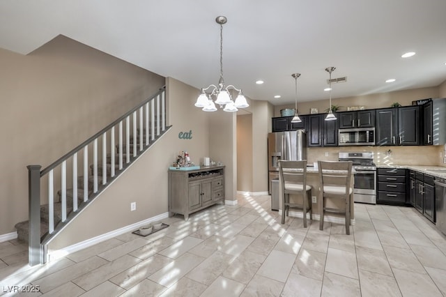 kitchen featuring decorative light fixtures, a notable chandelier, a center island, decorative backsplash, and appliances with stainless steel finishes