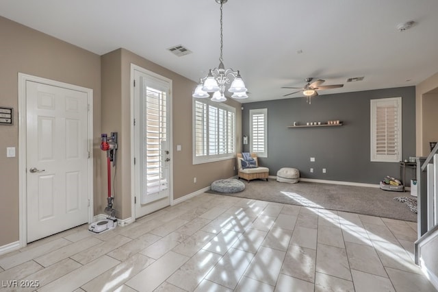 foyer entrance with light carpet and ceiling fan with notable chandelier