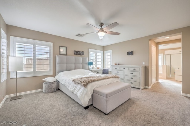 bedroom with ceiling fan, light colored carpet, and ensuite bathroom