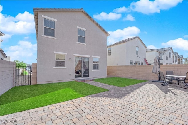 rear view of house with a patio area and a lawn