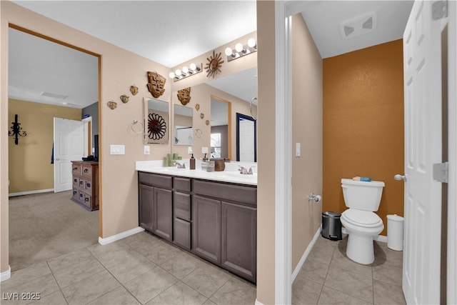 bathroom with toilet, vanity, and tile patterned floors