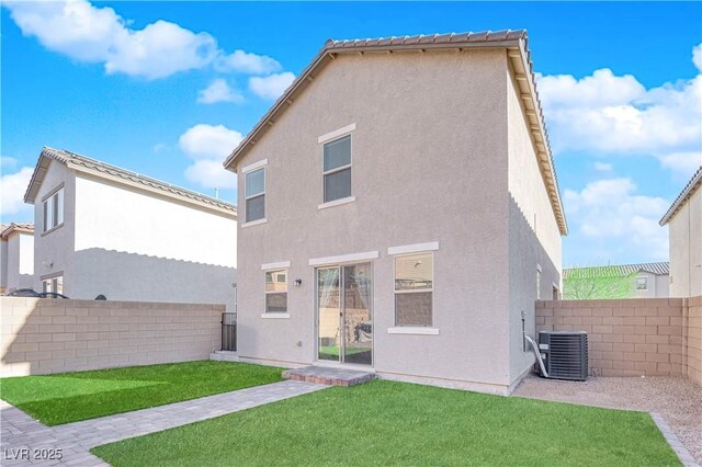 rear view of property with cooling unit and a yard