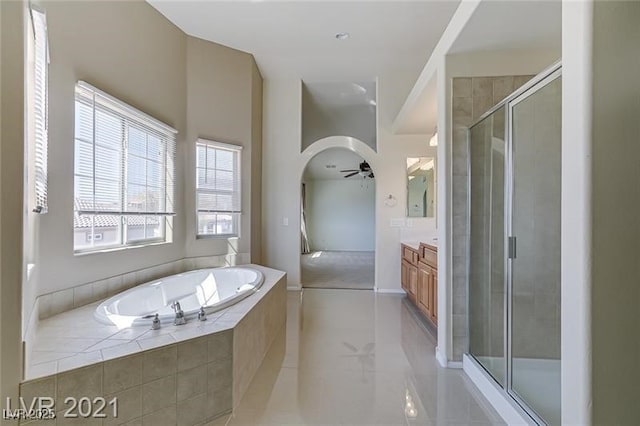 bathroom featuring ceiling fan, vanity, and shower with separate bathtub