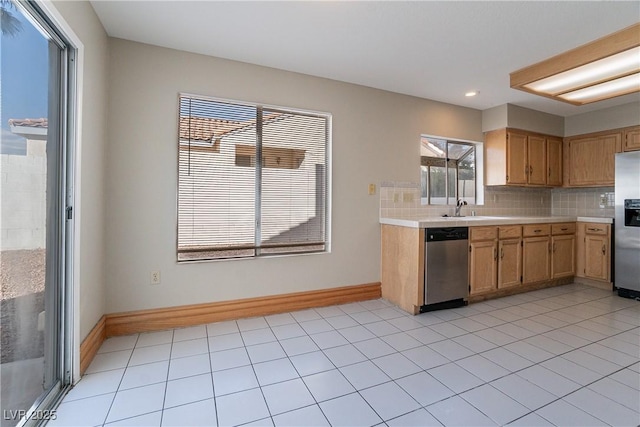 kitchen with a healthy amount of sunlight, backsplash, sink, and stainless steel appliances