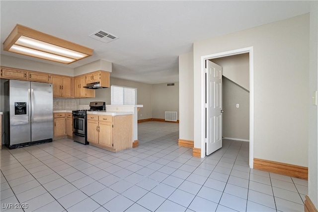 kitchen featuring decorative backsplash, light tile patterned floors, light brown cabinets, and appliances with stainless steel finishes