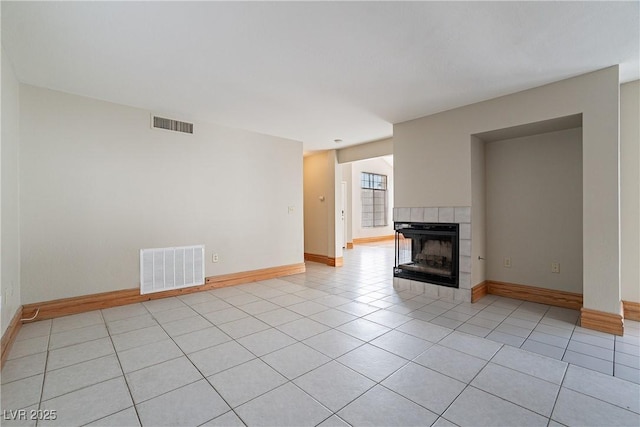 unfurnished living room featuring light tile patterned floors and a tile fireplace