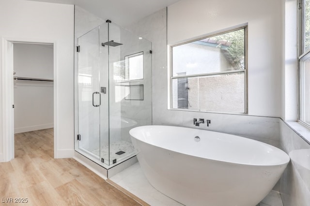 bathroom with hardwood / wood-style flooring and shower with separate bathtub