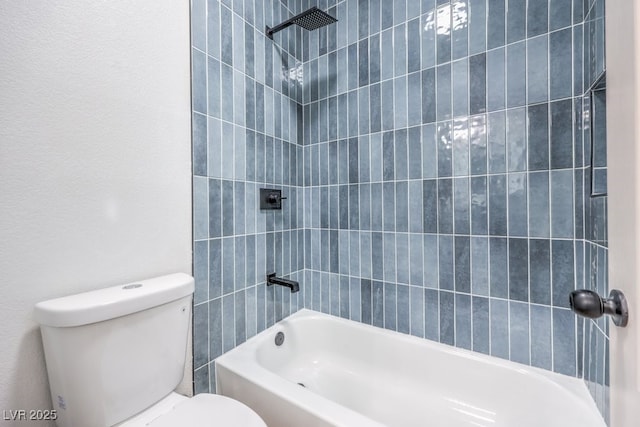 bathroom featuring tiled shower / bath combo and toilet