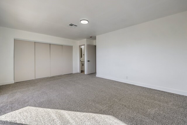 unfurnished bedroom featuring a closet and light carpet