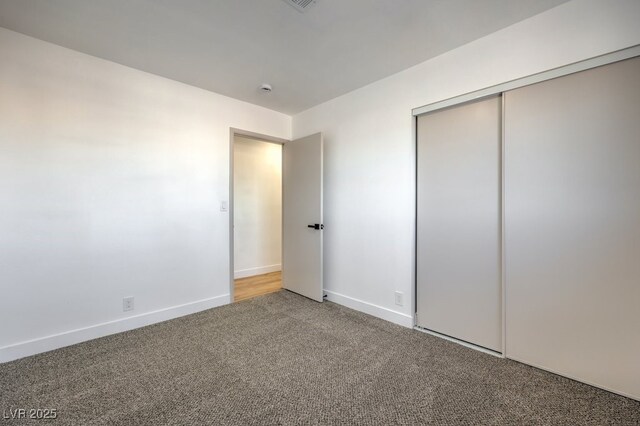 unfurnished bedroom with a closet and carpet flooring