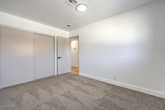 unfurnished bedroom featuring carpet floors and a closet