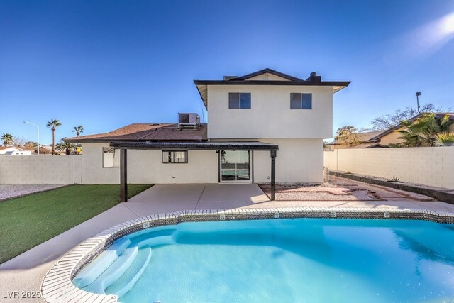 rear view of house featuring a patio area, a fenced in pool, central AC unit, and a yard