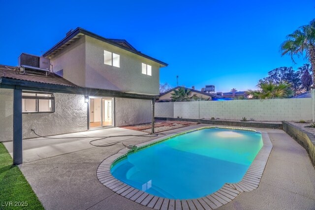 pool at dusk with central AC unit and a patio area