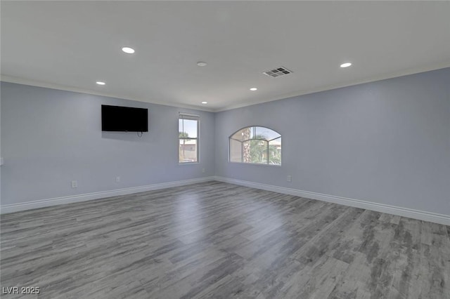 unfurnished room featuring light hardwood / wood-style flooring and crown molding