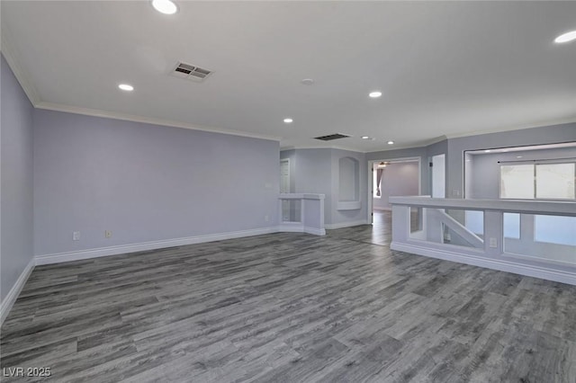 unfurnished living room featuring wood-type flooring and ornamental molding