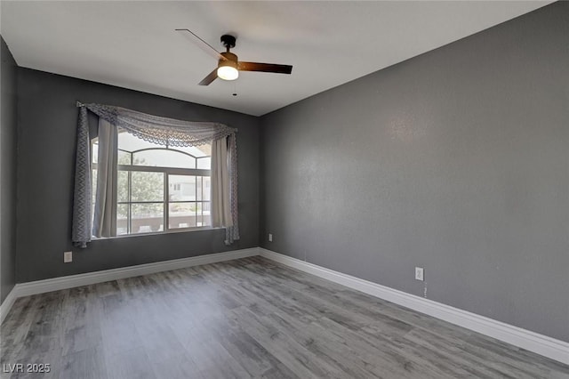 spare room with ceiling fan and light wood-type flooring