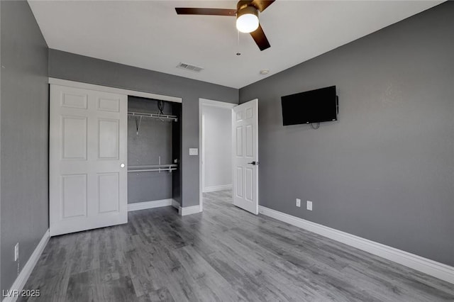 unfurnished bedroom with ceiling fan, a closet, and light wood-type flooring